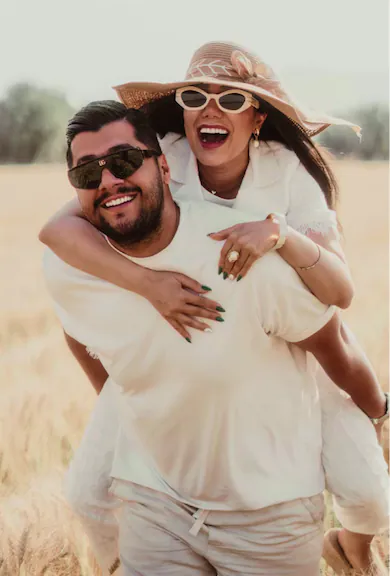 A man carried his loved woman on his back through the field. Romantic atmosphere.