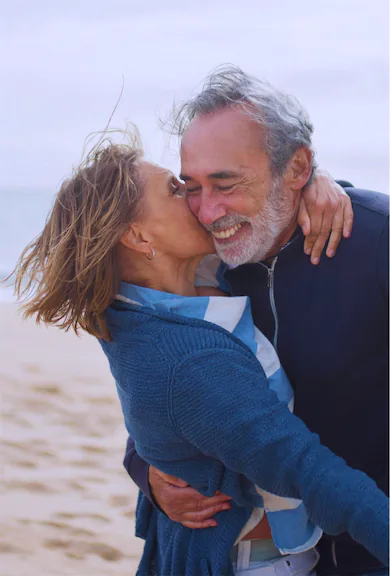 Well-established middle-aged couple having their romantic moment on the windy beach of Great Ontario Lake